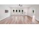 Bright living room featuring wood-look floors, a modern ceiling fan and several windows that fill the space with natural light at 6907 Lancaster Hwy, Waxhaw, NC 28173