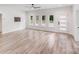 Bright living room featuring light wood floors, modern door, a ceiling fan, and abundant natural light at 6907 Lancaster Hwy, Waxhaw, NC 28173