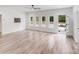 Bright living room featuring light wood floors, modern door, a ceiling fan, and abundant natural light at 6907 Lancaster Hwy, Waxhaw, NC 28173