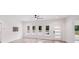 Bright living room featuring light wood floors, modern door, a ceiling fan, and abundant natural light at 6907 Lancaster Hwy, Waxhaw, NC 28173