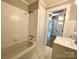 A full bathroom with bathtub and shower combo, tile surround, and storage at 717 Wilshire Sw Ave, Concord, NC 28025