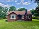 Charming brick home with a well-manicured lawn, flower beds, and a classic brick chimney at 717 Wilshire Sw Ave, Concord, NC 28025
