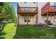 Backyard area with a small green lawn, and a building with a deck and covered patio at 7753 Jackson Pond Dr, Charlotte, NC 28273