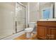 Clean bathroom featuring a shower with glass doors, toilet, and vanity with wood finish at 7753 Jackson Pond Dr, Charlotte, NC 28273