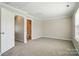 Spacious bedroom with neutral carpet, grey walls, and a view to an adjacent bathroom at 7753 Jackson Pond Dr, Charlotte, NC 28273