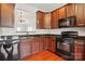 Well-appointed kitchen boasts wood cabinetry, black appliances, and a view to the living room at 7753 Jackson Pond Dr, Charlotte, NC 28273