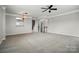 Spacious living room featuring plush carpet, light gray walls, and stairs leading to the second story at 7753 Jackson Pond Dr, Charlotte, NC 28273