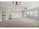 Expansive living room features neutral walls, plush carpeting, and ample natural light from large windows at 7753 Jackson Pond Dr, Charlotte, NC 28273