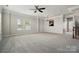 Bright, open-plan living room with neutral tones, plush carpet, and a view into the kitchen at 7753 Jackson Pond Dr, Charlotte, NC 28273