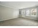 Bright living room with neutral carpet, natural light from a window, and a white door leading outside at 7753 Jackson Pond Dr, Charlotte, NC 28273