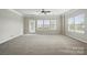 Spacious living room with neutral carpet, ceiling fan, lots of natural light, and a sliding glass door to the outside at 7753 Jackson Pond Dr, Charlotte, NC 28273