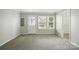 Bright living room with neutral carpet, natural light from a window, and a white door leading outside at 7753 Jackson Pond Dr, Charlotte, NC 28273
