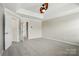 Spacious main bedroom featuring plush carpet, tray ceiling, and ceiling fan at 7753 Jackson Pond Dr, Charlotte, NC 28273