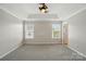 Serene main bedroom with tray ceiling, ceiling fan, soft carpet, and dual windows at 7753 Jackson Pond Dr, Charlotte, NC 28273