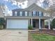 Inviting two-story home with brick accents, a two-car garage, and a classic front entrance at 8323 Carolina Laurel Ct, Charlotte, NC 28215