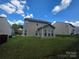Exterior view of the home's backyard with sunroom and green lawn at 8323 Carolina Laurel Ct, Charlotte, NC 28215