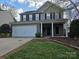 Charming two-story home featuring a brick facade, two-car garage, and inviting front porch at 8323 Carolina Laurel Ct, Charlotte, NC 28215