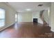 Spacious living room with hardwood floors, fireplace, and staircase access at 8323 Carolina Laurel Ct, Charlotte, NC 28215