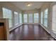Bright sunroom filled with natural light from large windows and wood flooring at 8323 Carolina Laurel Ct, Charlotte, NC 28215