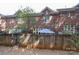 Fenced backyard with a view of the brick exterior of the home with windows and greenery at 879 Park Slope Dr, Charlotte, NC 28209