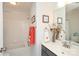 Well-lit bathroom showcasing a single sink vanity, and shower-tub combo with orange towels at 879 Park Slope Dr, Charlotte, NC 28209