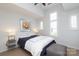 Comfortable bedroom featuring a white ceiling fan, big windows and an upholstered ottoman at 879 Park Slope Dr, Charlotte, NC 28209