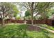 Well-maintained common area with green grass, brick wall, and mature trees with a bench at 879 Park Slope Dr, Charlotte, NC 28209