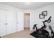 Bright exercise room featuring neutral carpet, Peloton bike, and modern square decoration at 879 Park Slope Dr, Charlotte, NC 28209