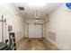 Spacious one car garage with white walls, storage rack, and garage door opener at 879 Park Slope Dr, Charlotte, NC 28209