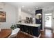 Modern kitchen featuring a breakfast bar, white cabinets, stainless steel appliances, and hardwood floors at 879 Park Slope Dr, Charlotte, NC 28209