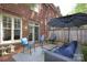 Brick patio features an outdoor seating area with lounge chairs, umbrella, and a view of the brick exterior at 879 Park Slope Dr, Charlotte, NC 28209