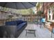 Private patio featuring cushioned seating, a wooden coffee table, and views of garden and partial brick house at 879 Park Slope Dr, Charlotte, NC 28209