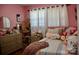 Pink bedroom featuring a striped bed, bedside table, and playful decor at 920 Squirrel Hill Rd, Charlotte, NC 28213