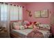 Playful bedroom decorated in pink, featuring a collection of stuffed animals and soft, natural lighting at 920 Squirrel Hill Rd, Charlotte, NC 28213