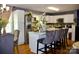 Well-lit kitchen with an island featuring bar seating, stainless appliances, and hardwood floors at 920 Squirrel Hill Rd, Charlotte, NC 28213