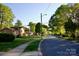 Residential street with houses and mature trees under a blue sky at 920 Squirrel Hill Rd, Charlotte, NC 28213