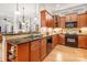 Open-concept kitchen featuring black appliances, wood cabinets, granite countertops, and natural light at 962 Blakeley Walk, Rock Hill, SC 29732