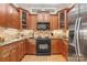 Kitchen with wood cabinetry, stainless steel refrigerator, and black appliances at 962 Blakeley Walk, Rock Hill, SC 29732