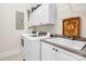 Well-lit laundry room with modern washer and dryer, utility sink, and plenty of cabinet space at 962 Blakeley Walk, Rock Hill, SC 29732