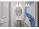 Modern powder room with pedestal sink, stylish lighting, and a framed abstract painting at 10033 Guardian Dr # 265, Charlotte, NC 28273