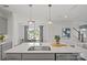 Modern kitchen boasts a large island, stainless steel sink, pendant lighting, and an open view to the dining area at 10033 Guardian Dr # 265, Charlotte, NC 28273