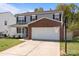 Charming two-story home with gray siding, brick accents, covered porch, two-car garage, and basketball hoop at 10937 Dry Stone Dr, Huntersville, NC 28078