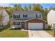 Charming two-story home with gray siding, brick accents, a covered porch, and a two-car garage at 10937 Dry Stone Dr, Huntersville, NC 28078