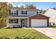 Charming two-story home with gray siding, brick accents, a covered porch, and a two-car garage at 10937 Dry Stone Dr, Huntersville, NC 28078