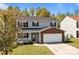 Charming two-story home with gray siding, brick accents, a covered porch, and a two-car garage at 10937 Dry Stone Dr, Huntersville, NC 28078