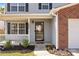 Inviting front porch with black shutters, white railings, manicured landscaping, and flowers by the door at 10937 Dry Stone Dr, Huntersville, NC 28078