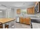 Clean kitchen features stainless appliances, tile backsplash, a window, and a wooden island with barstool seating at 10937 Dry Stone Dr, Huntersville, NC 28078