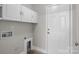 Well-lit laundry room with overhead storage and exterior access door at 10937 Dry Stone Dr, Huntersville, NC 28078