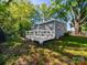 Backyard exterior showing a deck with lush green grass and mature tree backdrop at 1142 Mona Dr, Charlotte, NC 28206