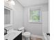 Well-lit bathroom with modern black fixtures, sleek vanity, and a window for natural light at 1142 Mona Dr, Charlotte, NC 28206